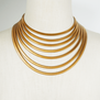 Gold plated necklace with seven strands of cobra chain on a mannequin.